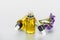 Bottles of natural oil and twig of dry limonium with flowers on white background.