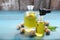 Bottles of nutmeg oil, pipette and nuts on turquoise wooden table, space for text