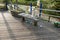 Bottles and other trash on a wooden bench on a boardwalk after a concert