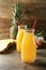 Bottles of pineapple juice on wooden table