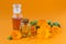 Bottles of pot marigold tincture or infusion and essential oil with a fresh Calendula flowers on orange background