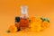 Bottles of pot marigold tincture or infusion and essential oil with fresh Calendula flowers on an orange background. Natural