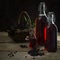 bottles with the red juice from black elderberries (Sambucus nigra) and a basket with berries on rustic wood, dark background, co