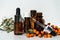 Bottles of sea buckthorn oil with a branch of sea buckthorn berries and a copy space.