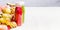 Bottles with smoothies and juices beverages on white table background with summer fruits and berries, front view, banner. Healthy