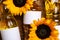 Bottles of sunflower cooking oil and beautiful flowers on wooden table, top view