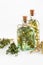 Bottles of thyme and rosemary essential oil and herbs bunches