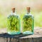 Bottles of thyme and rosemary essential oil or infusion outdoors