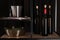 Bottles of wine, bucket and corkscrew on rack against black background
