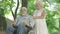 Bottom angle view of handicapped old man and caring senior woman talking in sunlight in summer park. Portrait of couple