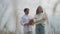 Bottom angle view portrait of smiling loving Caucasian young man walking with autumn bouquet to woman kissing hugging