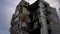 Bottom angle view of ruined ashed house at background of overcast sky in Kiev Ukraine. Destroyed residential building