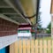 The bottom of the gutter under the edge of the roof in the new house of rural Yakutia with raindrops in wet weather.