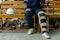 The bottom half of a man is sitting on a chair. in hand, walking crutches The left leg had a soft cast left after the accident. to