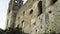 Bottom view of ancient fortress wall on background of sky. Action. Crumbling medieval stone fortress serves as tourist