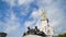 Bottom view of beautiful monument with sculptures on blue sky background. Action. Monument with human sculptures in