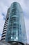 A bottom view of the beautiful multi-storey mirrored building of Cobra Business Centre on the background of the gloomy cloudy sky