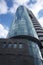 A bottom view of the beautiful multi-storey mirrored building of Cobra Business Centre on the background of the gloomy cloudy sky