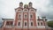 Bottom view of beautiful red facade of church. Action. Architecture of red stone church with Golden domes in Russian