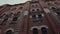 Bottom view of classic old fashioned red brick building, concept of architecture. Video. Beautiful ancient house on grey