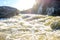 Bottom view of the dangerous rapid current of the river, foam and bubbling water in the daylight