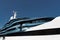 Bottom view of decks of huge yacht of blue color at sunny day, glossy board of the motor boat, sun reflection on glossy