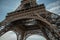 Bottom view of Eiffel Tower made in iron and Art Nouveau style, with sunny blue sky in Paris.