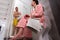 Bottom view of female in bathrobe with newspaper sitting on a to
