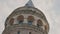 Bottom view of Galata Tower. Action. Ancient stone tower on background of blue sky. Historical stone tower in center of