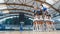 Bottom view of a group of cheerleaders in white and navy blue uniforms holding a member with pom-poms in hands up in