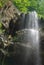 bottom view of man climbing up rope near waterfall, Russian Federation, Caucasus,