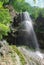 bottom view of man climbing up rope near waterfall, Russian Federation, Caucasus,