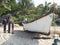 Bottom view of an old battered fishing wooden boat standing on a beach