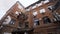 Bottom view of old brick building on background cloudy sky. Action. Red brick building in old town is used for offices