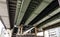 The bottom view of an overpass bridge in Osaka, shows a girder made of high tensile steel in green and gray