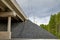 Bottom view of the prestressed concrete beams and piers of bridge crossing many-lane expressway of road