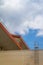 Bottom view of the roof of the industrial pavilion, fence and stairs over the blue sky and clouds