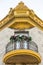 Bottom view of round wood and metal balcony and ornate golden cornice