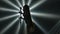 Bottom view is silhouette of female vocalist in short dress performing on stage with smoke and dynamic beams of light