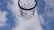 The bottom view of the slow clip of the ball floating into the basketball hoop and the net Background Beautiful Clouds Sky