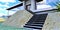 Bottom view of the steps of a stylish porch of an elite country cottage. The staircase is lined with slate. The facade is white