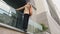 Bottom view stylish beautiful young girl stand on terrace near office building pensive female leaned forward and raise