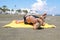 Bottom view on the teen boy feet in the sand lying on yellow towel and sunbathes on the beach.