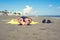 Bottom view on the teen boy feet in the sand lying on yellow towel and sunbathes on the beach.