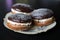 Boucher cakes with cream under chocolate icing on a beautiful white shaped plate on a black background