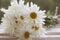 Bouguet of daisies close-up lying on an old windowsill against a blurred green garden.