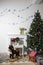 The bouguet ranunculus in a vase next to the background of a Christmas tree. Fireplace on the background of a white wall