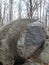 Boulder huge rock round trees grey sky