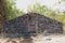 A boulder wall with closed wooden doors. Stone wall by the road in Bali Island, Indonesia. Enter the jungle. Mystical place with m