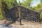 A boulder wall with open wooden doors. Stone wall by the road in Bali Island, Indonesia. Enter the jungle. Mystical place.